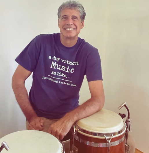 Michael smiling behind congas