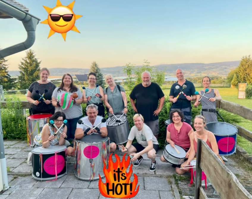 A workshop group outdoors holding surdos and mallets